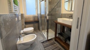 A modern bathroom with a toilet, bidet, shower, and sink. - Enchantment of the Lake app Riva Two-room apartment with Terrace and A/C (Molina)