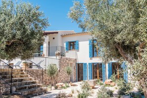 A two-story building with a stone staircase, blue shutters, and a balcony. - Luxury Villa Overlooking Sea (PM)