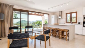 Uma cozinha moderna com área de bar, amplas janelas e vista para o exterior.