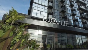 A modern building with a glass facade and the name 'DOVIL' prominently displayed. - Smart Loft-style 1br Apt Near to Shops (Panama City)