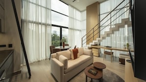 A modern living room with a sofa, coffee table, and a staircase. - Urban 2br Apt in Central Area (Panama City)