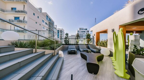 A rooftop terrace with outdoor seating, a staircase, and a view of surrounding buildings. - Flat in Regatta Ii 306 (Santo Domingo)