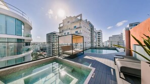 A rooftop pool area with a glass balustrade, a sun lounger, and a small enclosed seating area. - Flat in Regatta Ii 306 (Santo Domingo)