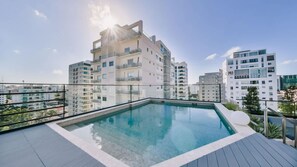 A rooftop swimming pool with a clear view of surrounding high-rise buildings. - Flat in Regatta Ii 306 (Santo Domingo)