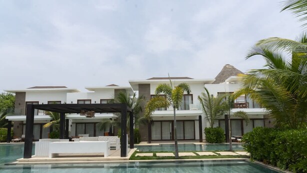 Un resort con piscina, architettura moderna e vista sulle montagne.