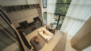 A modern interior with a kitchen, dining area, and a balcony with a pool view. - Family 2br Apt Near to Shopping Mall (Panama City)