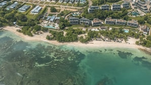 An aerial view of a coastal resort with multiple buildings, a beach, and clear waters. - Oceanview Penthouse w Terrace gym (Cartagena)