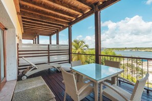 A covered outdoor area with a table and chairs, a wooden ceiling, and a view of the ocean. - Studio 3 Guests Balcony With Views Fishing Lodge (Punta Cana)