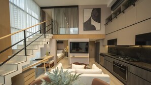 A modern interior with a staircase, a dining area, a living room, and a kitchen. - Luxury 2br Apt Pool Access (Panama City)