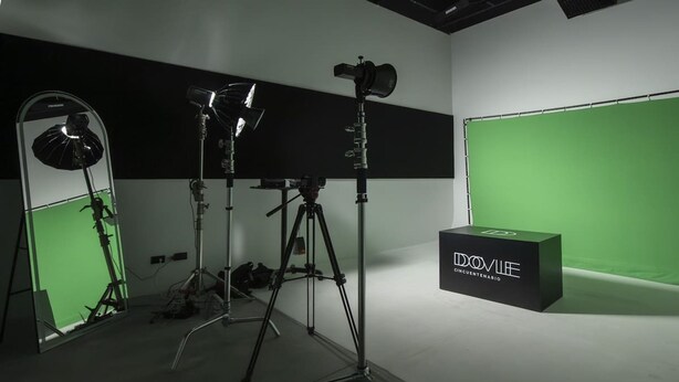 Un estudio con equipo de iluminación y un fondo de pantalla verde.