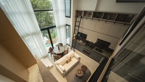 A modern apartment with a dining area, kitchen, and a large window with curtains. - Cozy Urban Loft 1br Near Coast (Panama City)