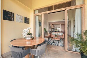 Uma sala de jantar com uma mesa de madeira, cadeiras e um vaso com planta.