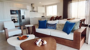 A modern living room with a sofa, coffee table, and chairs. - 2br 4 Guests Balcony and Pool View Cap Cana (Punta Cana)