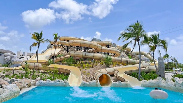 A water park with multiple slides and a pool. - Cozy 1br w Balcony Pool Beach Access Cap Cana (Punta Cana)