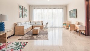 A spacious living room with a sofa, a coffee table, a side table, and a desk. - Apartment w 2br Close to the Beach at Portillo X (Las Terrenas)