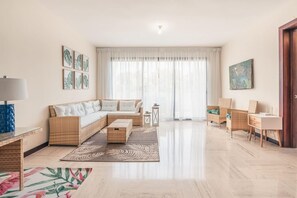 Ein geräumiges Wohnzimmer mit einer Couch, einem Couchtisch, einem Beistelltisch und einem Schreibtisch.