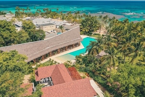 Un resort con piscina, palmeras y playa.