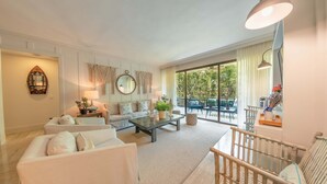 Ein geräumiges Wohnzimmer mit einer Couch, einem Couchtisch und Blick ins Freie.