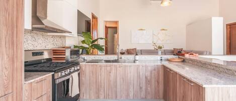 Una cocina con armarios de madera, estufa y encimera.