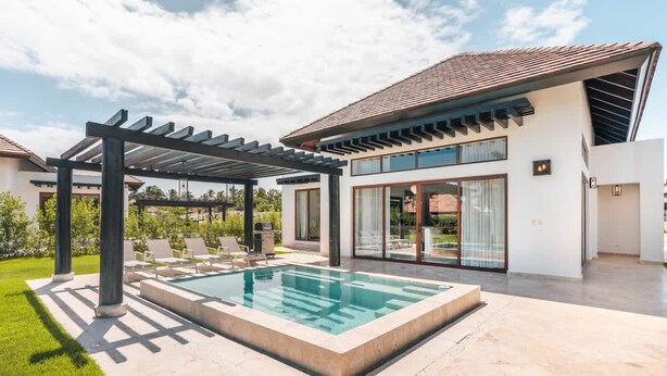 A modern house with a swimming pool, covered patio, and large windows.