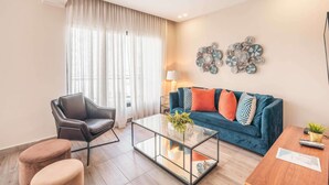 A living room with a sofa, coffee table, and a chair. - Flat in Piantini 302 (Santo Domingo)