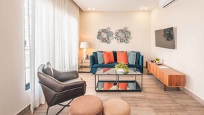 A modern living room with a sofa, coffee table, and a TV mounted on the wall. - Flat in Piantini 302 (Santo Domingo)