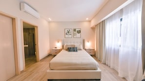 A bedroom with a bed, bedside tables, a door, and a window with curtains. - Flat in Regatta Ii 304 (Santo Domingo)