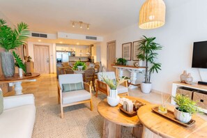 Un salon moderne avec un canapé, des fauteuils, une table basse et des plantes en pot.
