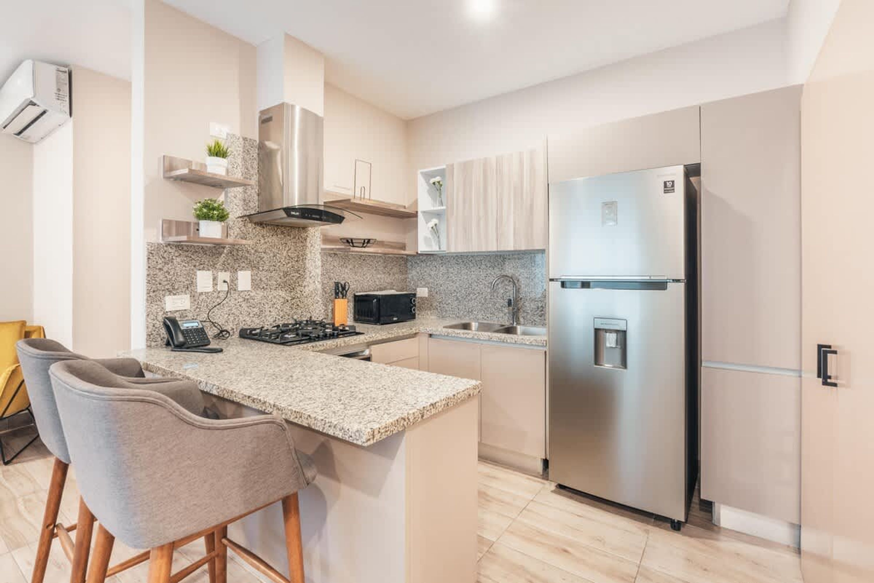 Een moderne keuken met een centraal eiland, roestvrijstalen apparatuur en een inbouwoven.