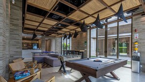 A modern indoor recreational area with a pool table, seating, and a foosball table. - 3-bedroom Apartment With Ocean Views in Baru (Cartagena)