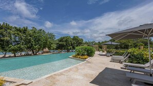 A pool area with clear water, lounge chairs, and umbrellas. - 3-bedroom Apartment With Ocean Views in Baru (Cartagena)