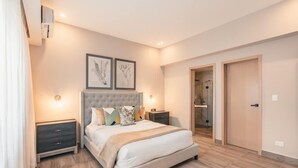 A bedroom with a bed, bedside tables, a wardrobe, and a shower area. - Regatta Living Ii - 406 (Santo Domingo)