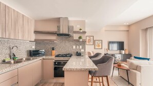 A modern kitchen with granite countertops, a gas stove, and a built-in oven. - Regatta Living Ii - 406 (Santo Domingo)