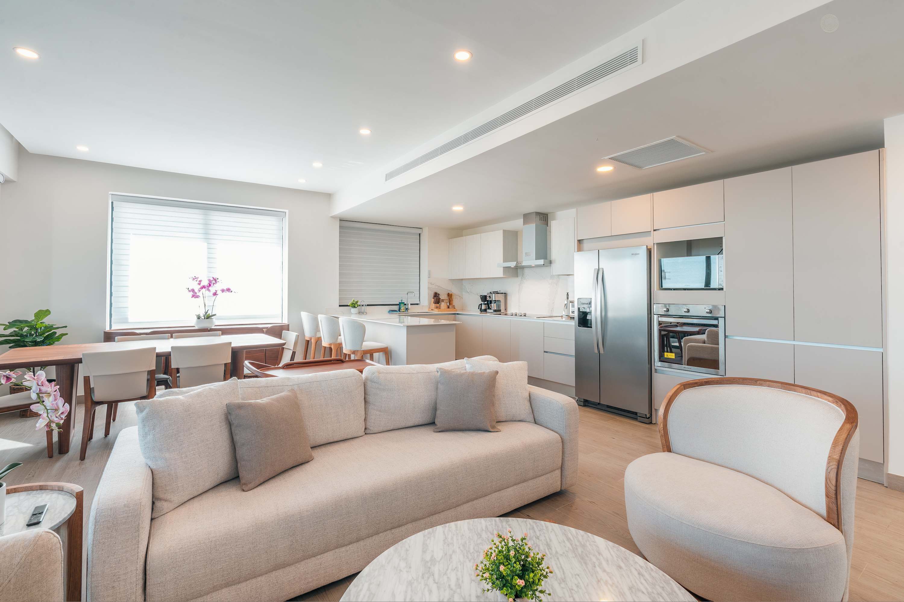 Una sala de estar moderna con sofá, una mesa de centro y un comedor con sillas.