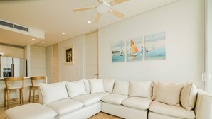 A modern living room with a sectional sofa, wooden chairs, a coffee table, and a ceiling fan. - Two Bedrooms apt With Views in Baru With Jacuzzi (Cartagena)