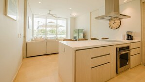 A modern kitchen with a central island, built-in oven, and a clock on the wall. - Two Bedrooms apt With Views in Baru With Jacuzzi (Cartagena)