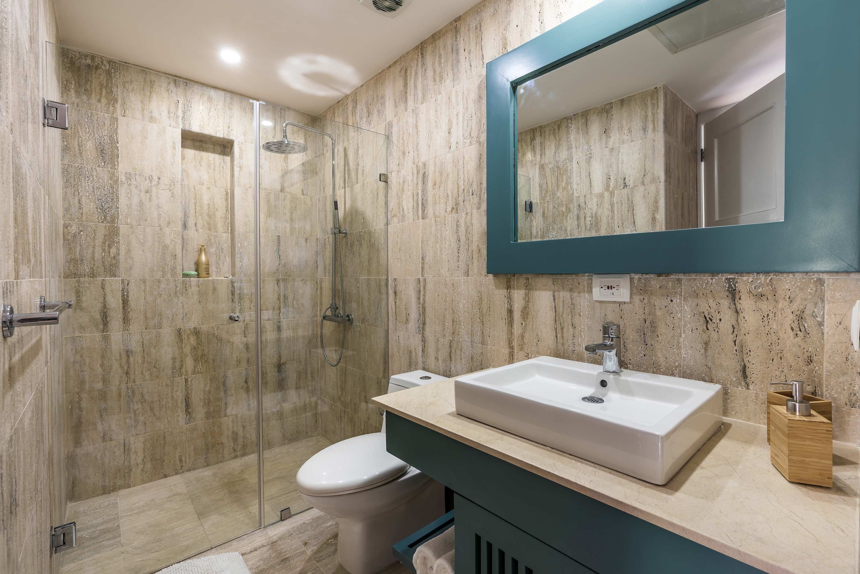 A modern bathroom with a glass-enclosed shower, a white sink, and a large mirror.