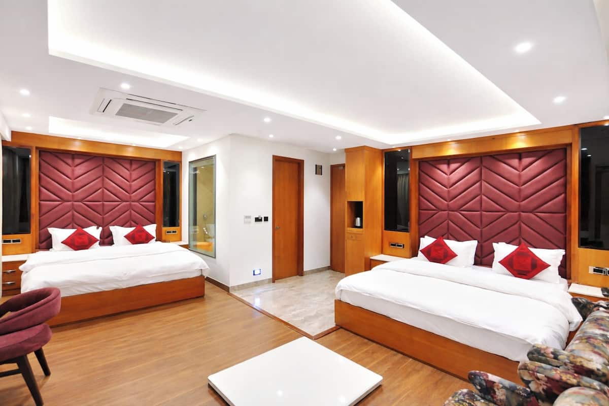 Ein modernes Hotelzimmer mit zwei Betten, Holzkopfteilen und einem großen Fenster.