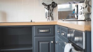 A kitchen with dark cabinetry, a microwave, and a wooden countertop. - Spacious Home Ideal For Families Free Parking (Chester)