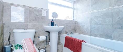 A bathroom with a toilet, sink, and bathtub.