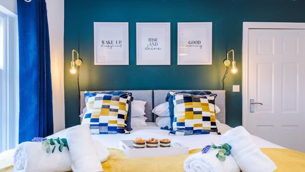 A hotel room with a bed, wall art, and a door. - Cosy House Amazing Location Perfect for Couples (Chester)