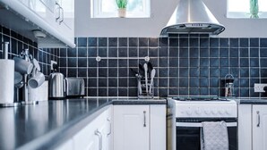 Eine moderne Küche mit Herd, Backofen und einer schwarzen Küchenwand.