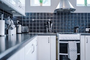 Eine moderne Küche mit Herd, Backofen und einer schwarzen Küchenwand.