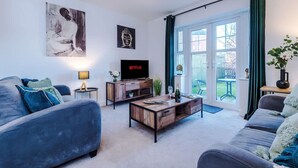Ein stilvolles Wohnzimmer mit einer Couch, einem Couchtisch und einem Kunstwerk an der Wand.