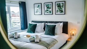 Una habitación de hotel con una cama, una lámpara de noche y tres cuadros en la pared.