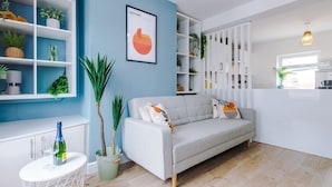 A modern living room with a grey sofa, white shelves, and a blue accent wall. - Stylish Home Incredible Location Sleeps 5 (Chester)