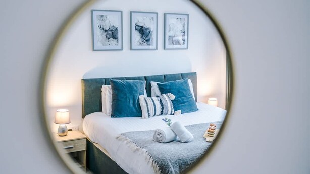 A bedroom with a bed, nightstands, and wall-mounted artwork. - Modern Apartment Ideal for Business Sleeps 3 (Crewe)