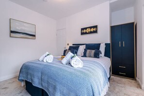 A bedroom with a bed, a wardrobe, and a wall-mounted artwork. - Stunning 3-bed House Amazing Location Sleeps 5 (Nantwich)