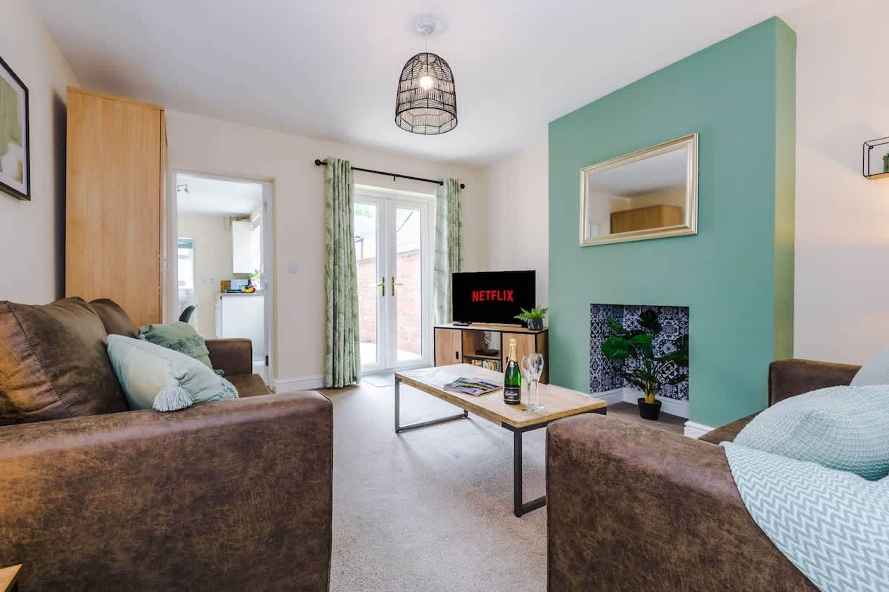 A living room with a sofa, a coffee table, a TV, and a fireplace.