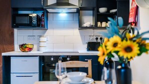 Eine moderne Küche mit Mikrowelle, Backofen und einem Essbereich mit einer Vase voller Sonnenblumen.